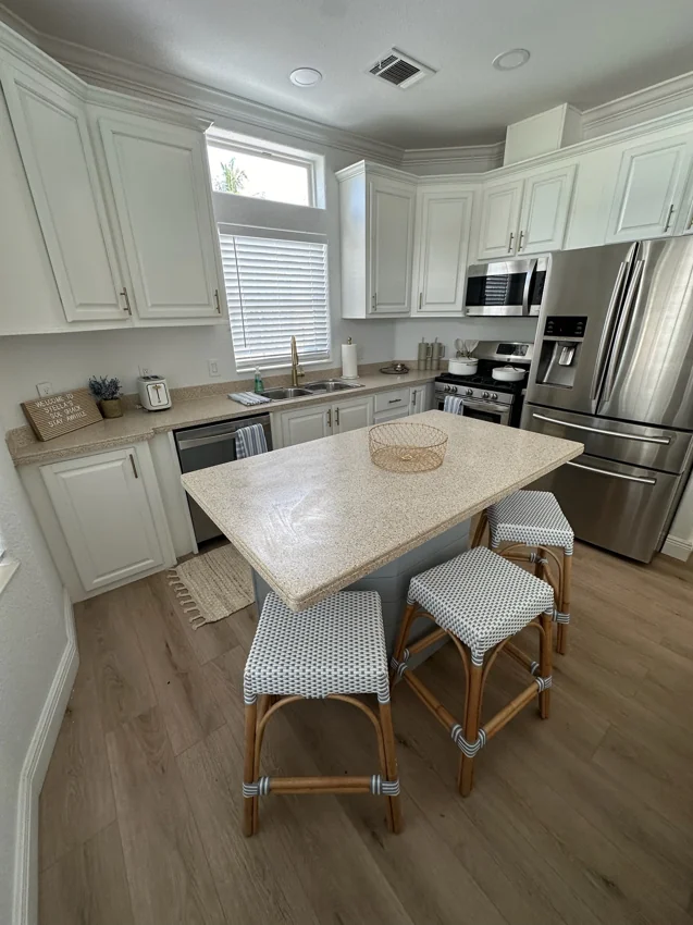 The full kitchen with island seating and stainless-steel appliances.